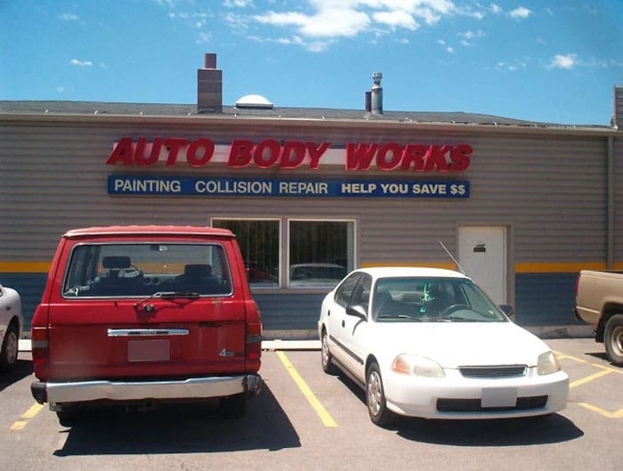 shop-sign Picture of the outside of the ship with a electric sign reading Auto Body Works and Collision